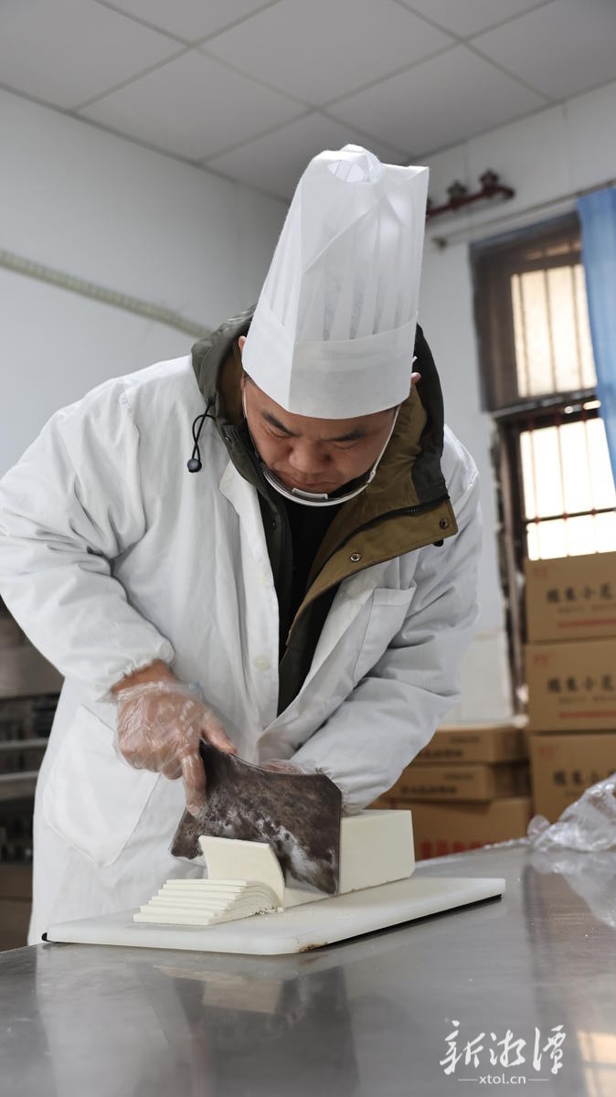 非遗传承人胡军在手工切灯芯糕。（全媒体记者 李新辉摄）.JPG